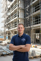 White male in navy polo on construction site